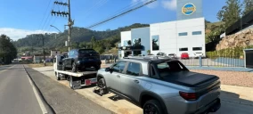 Guincho plataforma estacionado na rua, transportando um veículo preto, em Rio do Sul.