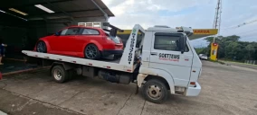 Guincho plataforma em Ivoti transportando um carro vermelho estacionado.