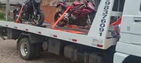 Guincho plataforma em Ivoti transportando duas motos amarradas com cintas laranjas.