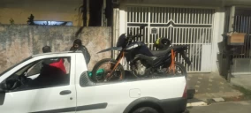 Guincho tipo pick-up branco transportando uma motocicleta preta e laranja em Santo André.