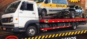 Guincho plataforma transportando um veículo off-road e uma van escolar em Diadema.