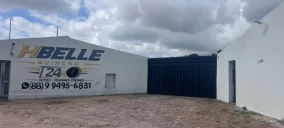 Imagem de um prédio com a fachada branca e uma parede azul, localizado em Crato, CE, sem veículos visíveis.