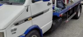 Guincho plataforma da marca Iveco, estacionado em Suzano, com ferramentas visíveis na parte traseira.