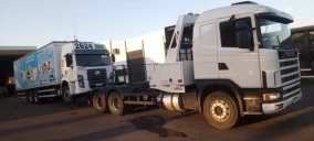 Guincho plataforma em Cascavel, transportando caminhão com carroceria azul e detalhes em branco.