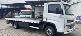 Guincho plataforma branco estacionado em área coberta com outros veículos ao fundo em Belém.
