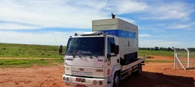Guincho plataforma estacionado em área rural, com caminhão branco e cabine visível, em Bauru.