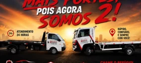 Imagem de dois guinchos de plataforma estacionados, um branco e um vermelho, com fundo de pôr do sol em Araçoiaba da Serra.