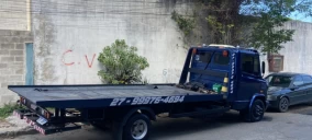 Guincho plataforma azul estacionado em Viana, sem veículo transportado visível.