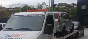 Guincho plataforma transportando um veículo SUV prata em Itaquaquecetuba.